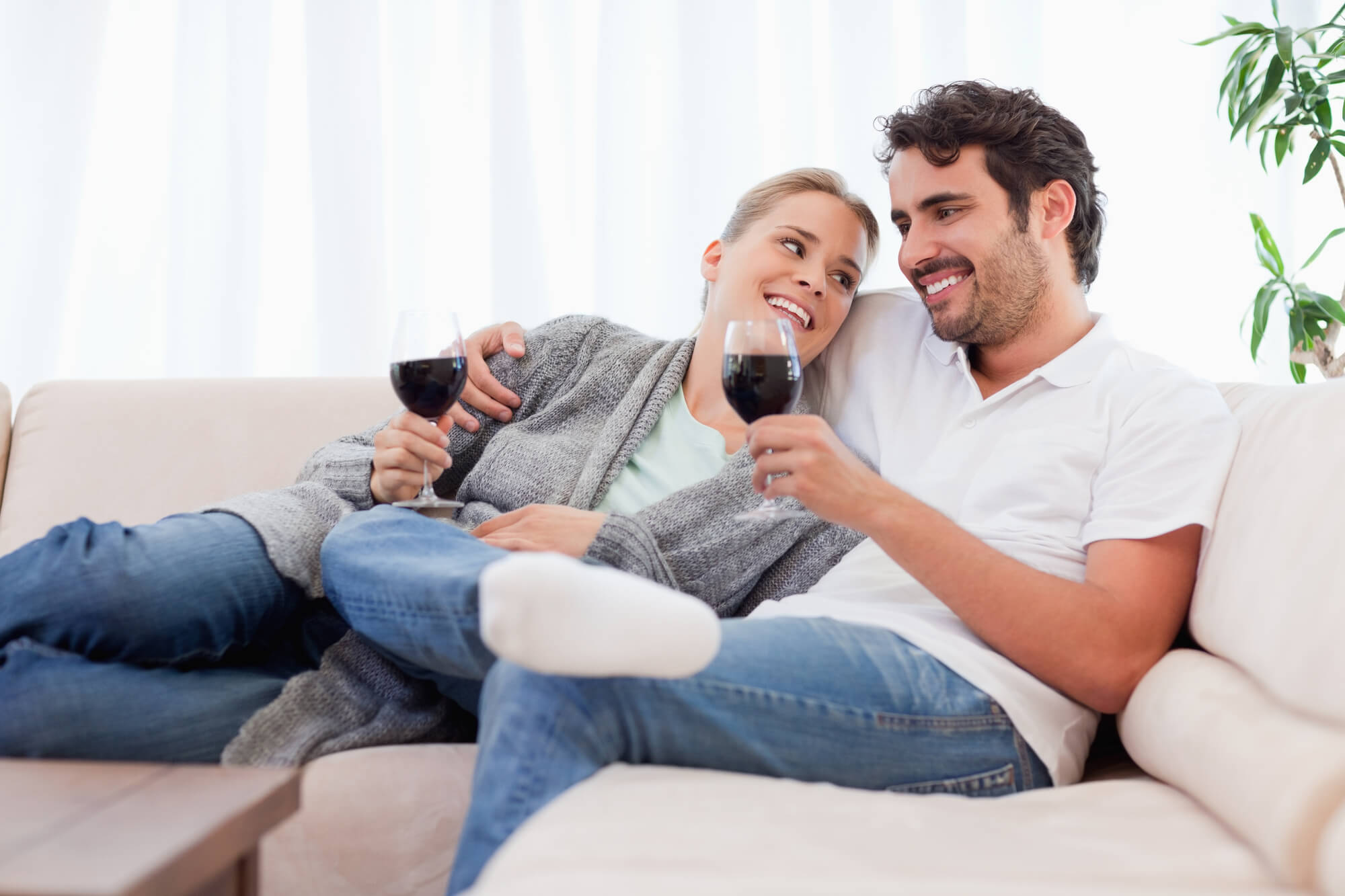 Couple drinking a glass of  red wine in their living room